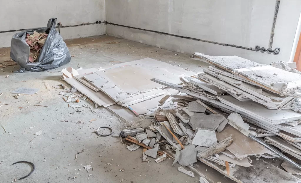 Room filled with construction debris including drywall and miscellaneous materials