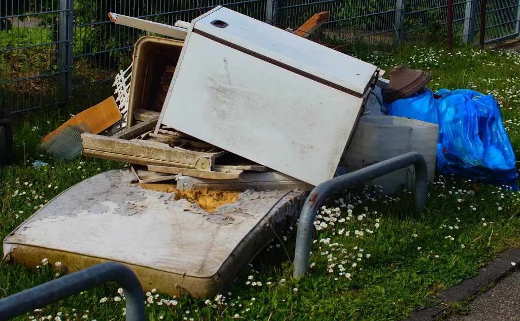 Pile of junk with an old refrigerator and mattress ready for Haulin’ Ass Junk Removal service