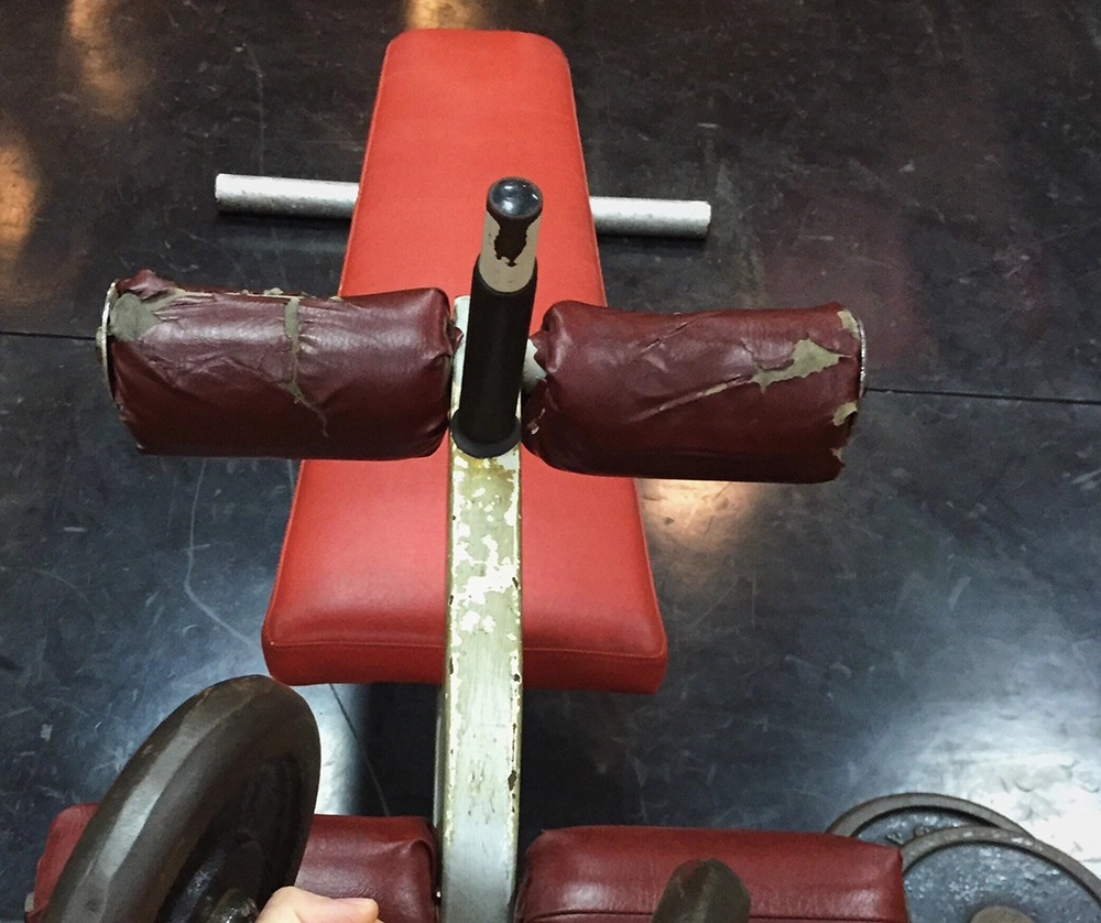 Old bench press bench ready for professional gym equipment removal service