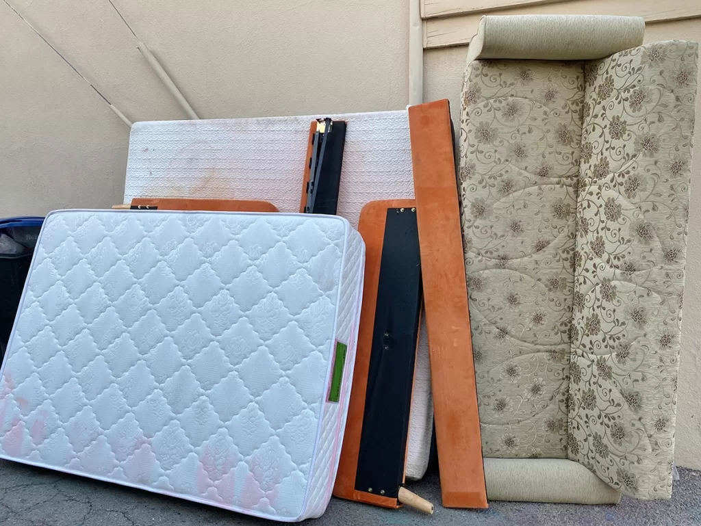 Old couch, mattress, and bed frame ready for residential furniture removal